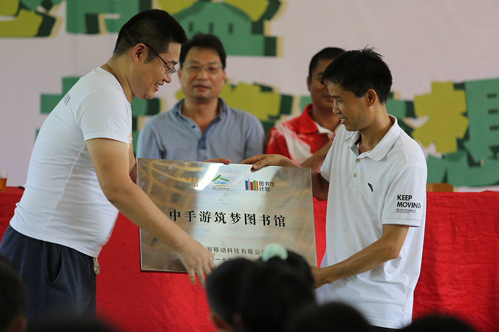 中手游合伙人兼副总裁王涛把“中手游筑梦图书馆”交予承平小学校长龙远报